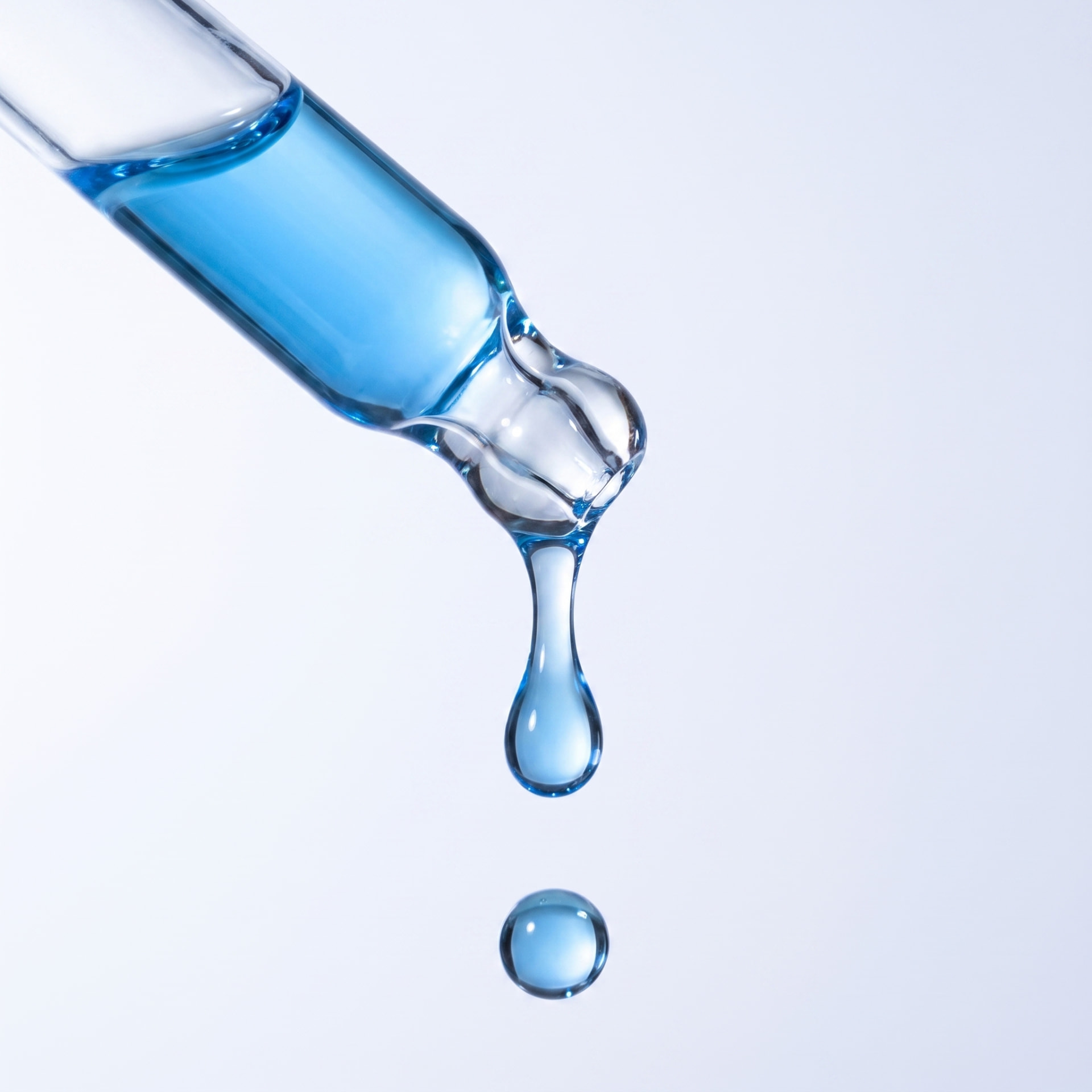 Blue GHK-Cu serum falling from a glass dropper